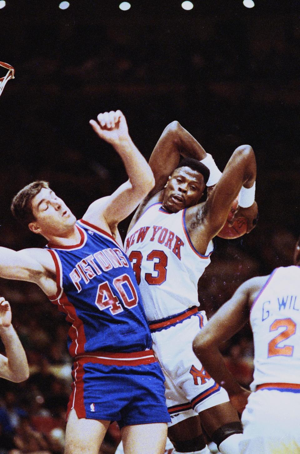 The New York Knicks' Patrick Ewing grabs a rebound away from the Detroit Pistons' Bill Laimbeer in the first period of the playoff game at Madison Square Garden, May 12, 1990.