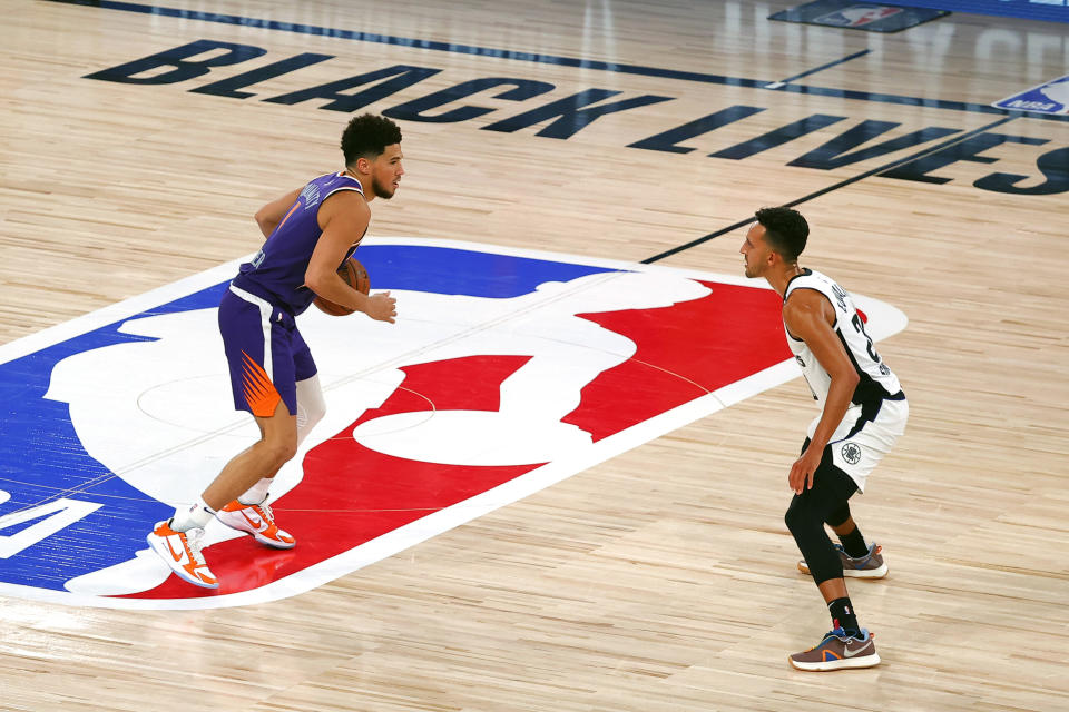 Los Angeles Clippers' Landry Shamet, right, defends Phoenix Suns' Devin Booker during an NBA basketball game Tuesday, Aug. 4, 2020, in Lake Buena Vista, Fla. (Kevin C. Cox/Pool Photo via AP)