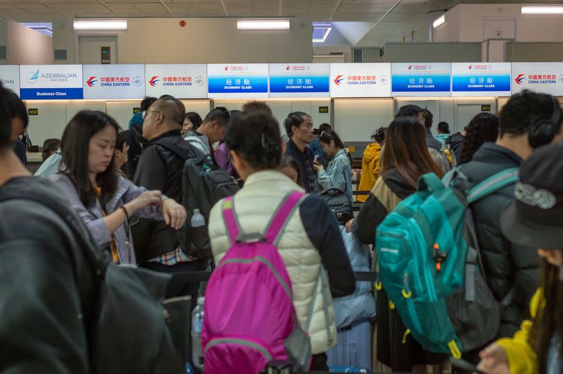 Chinese passengers queue to check in for a China Eastern flight to Shanghai from London Gatwick Airport, UK. (Photo by: Andy Soloman/UCG/Universal Images Group via Getty Images)