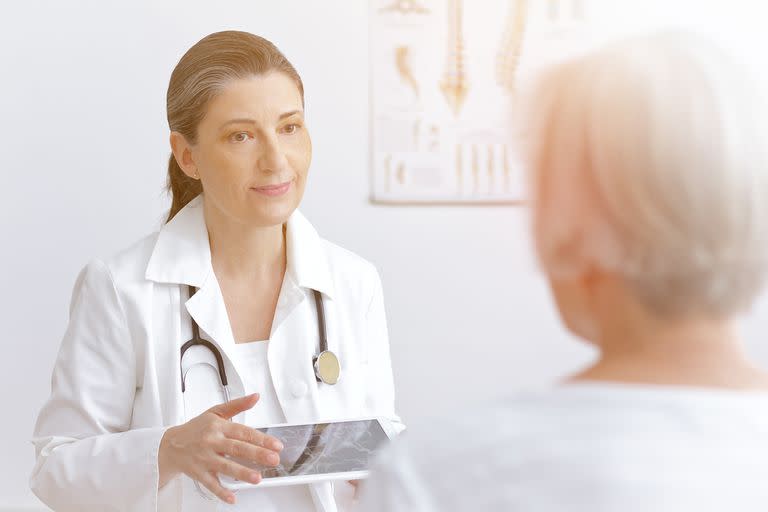 Female doctor with an mra image or angiogram discussing with a senior patient her risk to suffer an apoplectic stroke, copy space