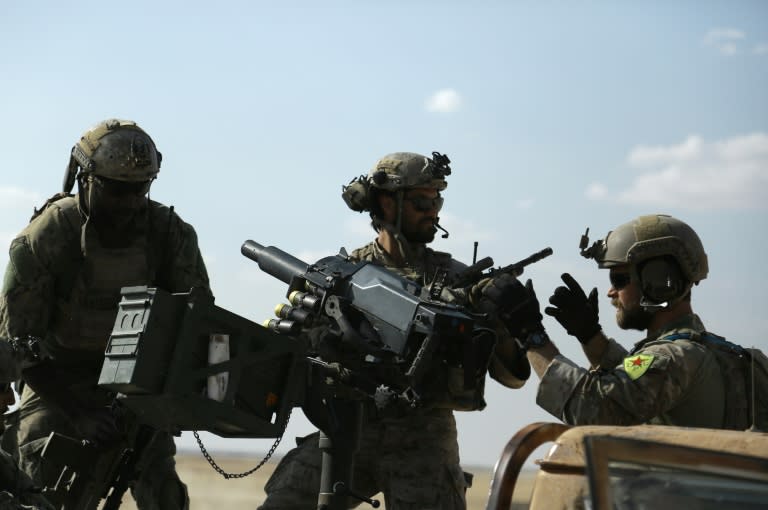 Troops identified by Syrian Democratic forces as US special operations forces ride in the back of a pickup truck in the village of Fatisah in the northern Syrian province of Raqa