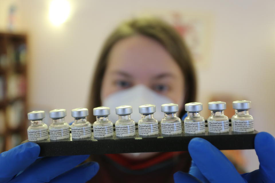 An employee of a mobile vaccination team in Halberstadt holds a tray with vaccination pads from the company Biontech/Pfizer in Halberstadt, Germany, Friday, Jan.15, 2021. (Matthias Bein/dpa via AP)