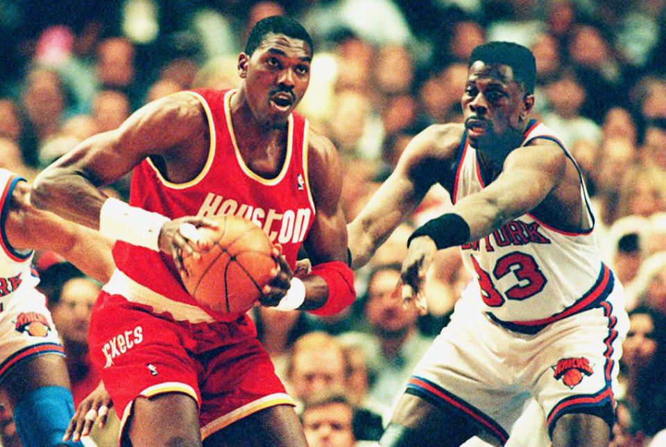 Hakeem Olajuwon (34) de los Houston Rockets busca pasar el balón ante la presión defensiva de Patrick Ewing de los New York Knicks durante el primer cuarto del Juego 5 de las Finales de la NBA de 1994 en el  Madison Square Garden, el 17 de junio de 1994. (Foto de BOB STRONG/AFP via Getty Images)