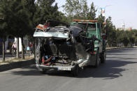 Security personnel remove a damaged minivan after a bomb explosion in Kabul, Afghanistan, Saturday, June 12, 2021. Separate bombs hit two minivans in a mostly Shiite neighborhood in the Afghan capital Saturday, killing several people and wounding others, the Interior Ministry said. (AP Photo/Rahmat Gul)