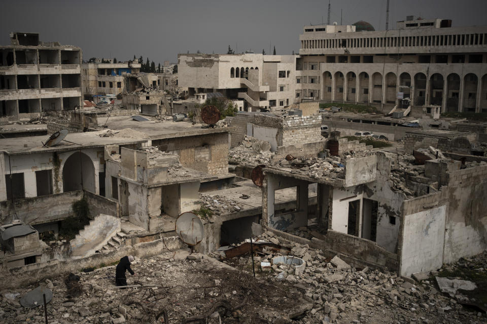 In this Thursday, March 12, 2020 photo, a woman stands atop a building in a neighborhood heavily damaged by airstrikes in Idlib, Syria. Idlib city is the last urban area still under opposition control in Syria, located in a shrinking rebel enclave in the northwestern province of the same name. Syria’s civil war, which entered its 10th year Monday, March 15, 2020, has shrunk in geographical scope -- focusing on this corner of the country -- but the misery wreaked by the conflict has not diminished. (AP Photo/Felipe Dana)