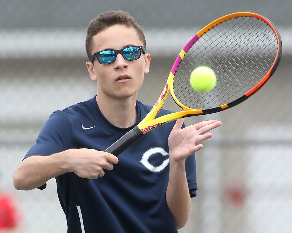 Cohasset #2 Archer Merton eyes the ball while working on his net game before his match against Hingham at Hingham High School on Saturday, May 21, 2022.