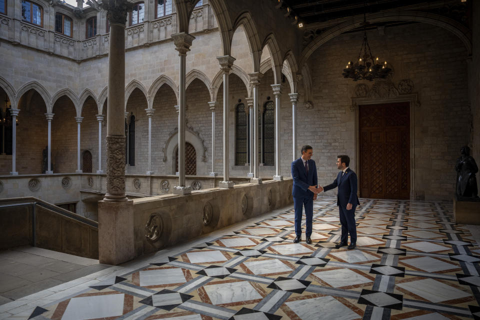 Spanish Prime Minister Pedro Sanchez, left, shakes hands with Catalonia's President Pere Aragones in Barcelona, Spain, Thursday, Dec. 21, 2023. Sanchez and Aragones meet in the first encounter since an amnesty for Catalan separatists was announced earlier this year. (AP Photo/Emilio Morenatti)