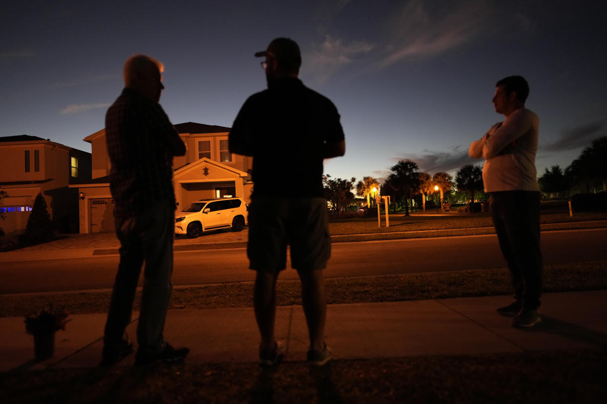 Brazilian supporters of former Brazil President Jair Bolsonaro gather outside the house in a resort community where he has been staying, in hopes of getting to greet him, Monday, Jan. 9, 2023, in Reunion, Fla. As Brazil reels from mobs of rioters swarming its seats of power, its former leader has decamped to a Florida resort, where droves of supporters have flocked to cheer on their ousted president.(AP Photo/Rebecca Blackwell)