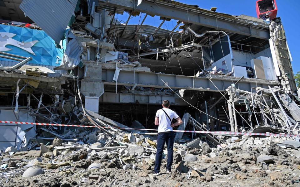 A man looks at a supermarket, partially destroyed by a missile attack on the southeastern outskirts of the Ukrainian city of Kharkiv on June 8, 2022. - Sergey Bobok/AFP