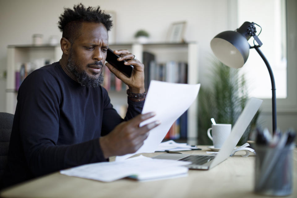 A man on the phone and looking at a paper