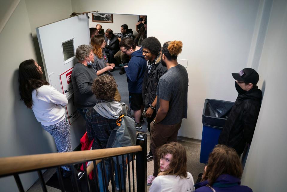 People overflow into a hallway to listen to public comment before a vote about banning the LGBTQ Pride flag on government buildings and city property, including other flags representing racial and political issues, during a city council meeting at Hamtramck City Hall on Tuesday, June 13, 2023.