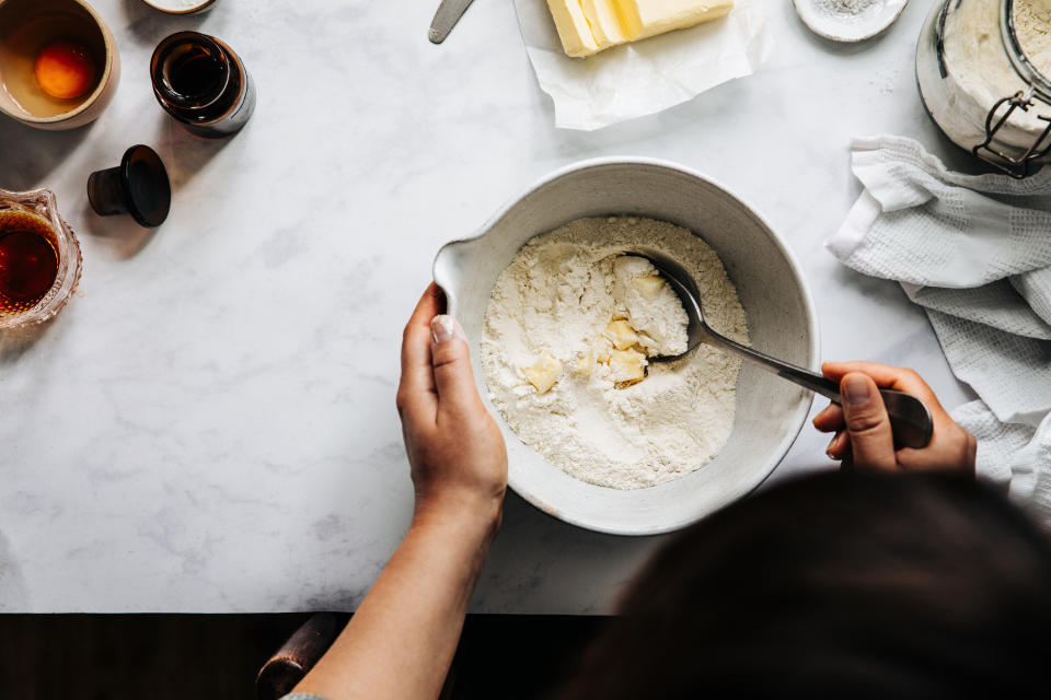 Directly above photograph of a woman preparing fruit pie dough