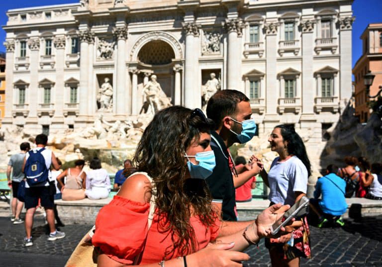 Des touristes le 19 août 2020 devant la Fontaine de Trevi à Rome: depuis lundi, le port des masques est  obligatoire en Italie le soir dans les lieux publics fréquentés  - Vincenzo PINTO © 2019 AFP