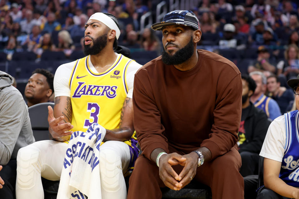 The Los Angeles Lakers' Anthony Davis sits on the bench next to LeBron James, who did not play in their preseason game against the Golden State Warriors, at Chase Center in San Francisco, on Oct. 7, 2023. (Photo by Ezra Shaw/Getty Images)