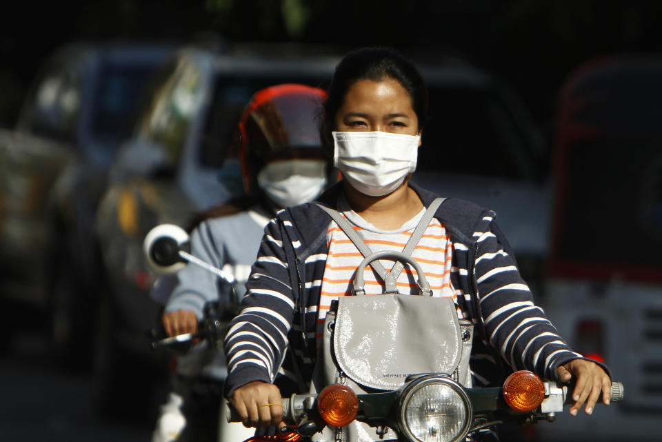 Cambodian school girls wear face masks as they drive their motorbikes back home at the end of their school outside Phnom Penh, Cambodia, Wednesday, Feb. 3, 2021. (AP Photo/Heng Sinith)