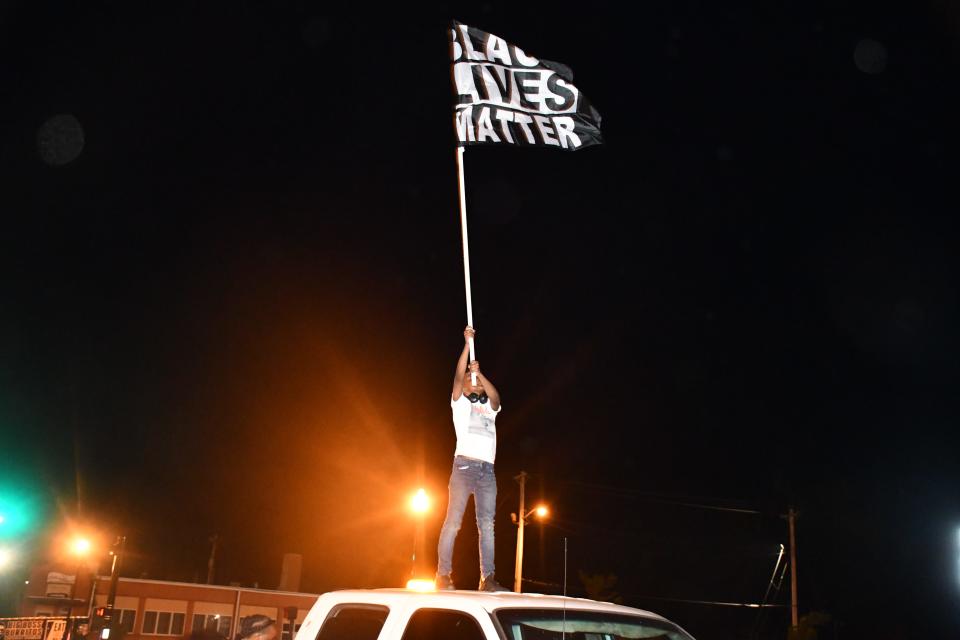 A child holds a Black Lives Matter flag during an eighth night of protest in Elizabeth City, N.C., after a judge ruled Wednesday not to release bodycam footage of sheriff's deputies fatally shooting Andrew Brown Jr.