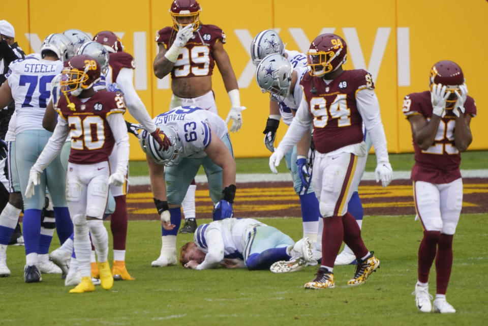 Players reacting to seeing Dallas Cowboys quarterback Andy Dalton (14) lying on the ground after getting hit by Washington Football Team inside linebacker Jon Bostic (53) in the second half of an NFL football game, Sunday, Oct. 25, 2020, in Landover, Md. (AP Photo/Susan Walsh)