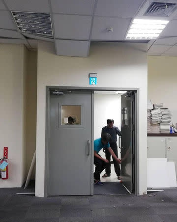 People stand next to door below collapsed ceiling in an office building after a quake in New Taipei City, Taiwan, April 18, 2019 in this picture obtained from social media. Kee Kei Wai via REUTERS