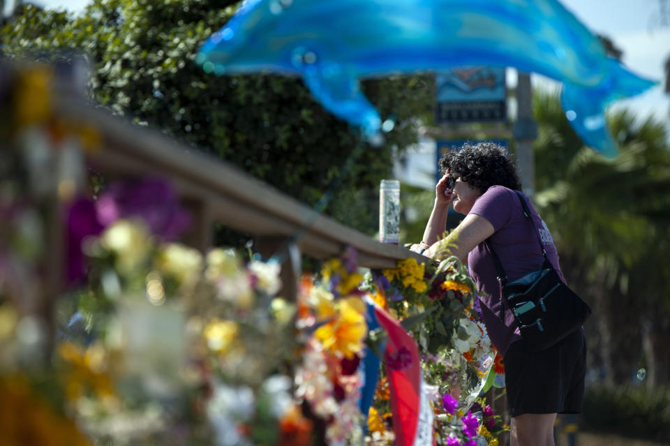 FILE - In this Sept. 4, 2019, file photo, a woman becomes emotional after placing flowers at a memorial for the victims of the Conception dive boat fire in the Santa Barbara Harbor in Santa Barbara, Calif. The widow of Justin Dignam, one of the 34 people who died in the fire, has filed a lawsuit against the boat's owners, making it the first claim from one of the 34 victims' families. (AP Photo/Christian Monterrosa, File)