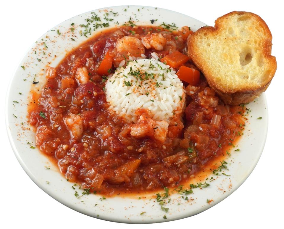 Shrimp creole in a bowl with bread and rice