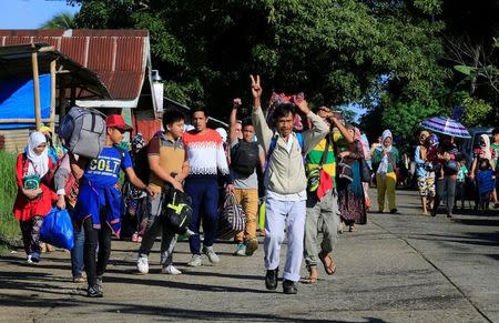 Residents carrying belongings walk along a main street to proceed to a evacuation center outside of Marawi city after government troops continued with an assault on fighters from the Maute group who have taken over large parts of Marawi city, Philippines May 26, 2017. REUTERS/Romeo Ranoco