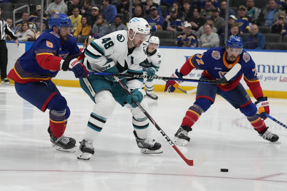 San Jose Sharks' Tomas Hertl (48) brings the puck down the ice as St. Louis Blues' Marco Scandella (6) and Justin Faulk (72) defend during the third period of an NHL hockey game Thursday, March 9, 2023, in St. Louis. (AP Photo/Jeff Roberson)