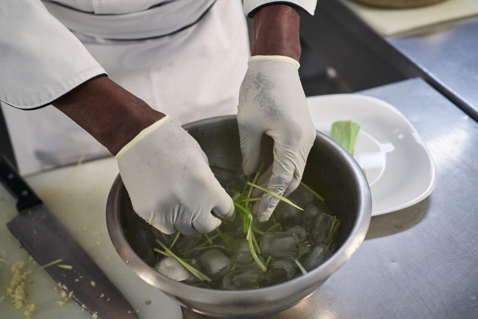 Someone putting veggies in iced water