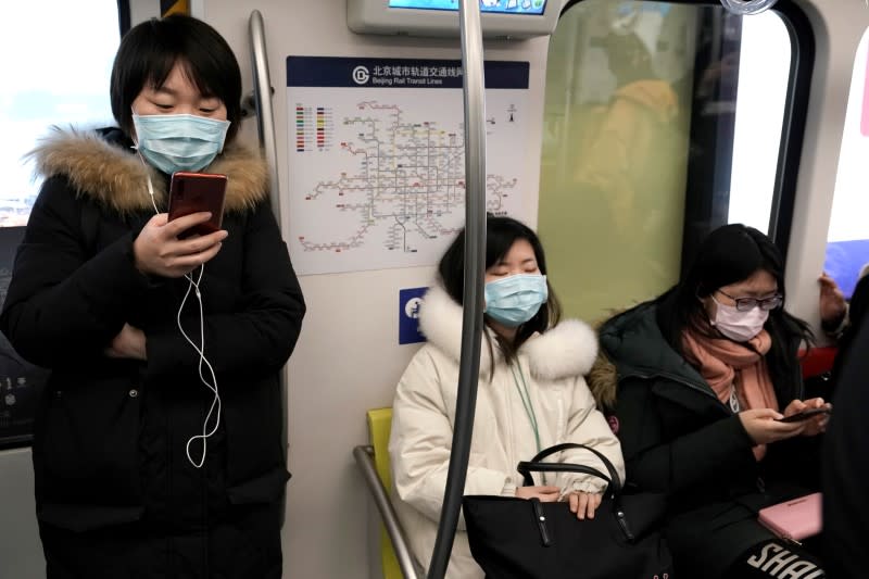 People wearing masks are pictured on the subway in Beijing