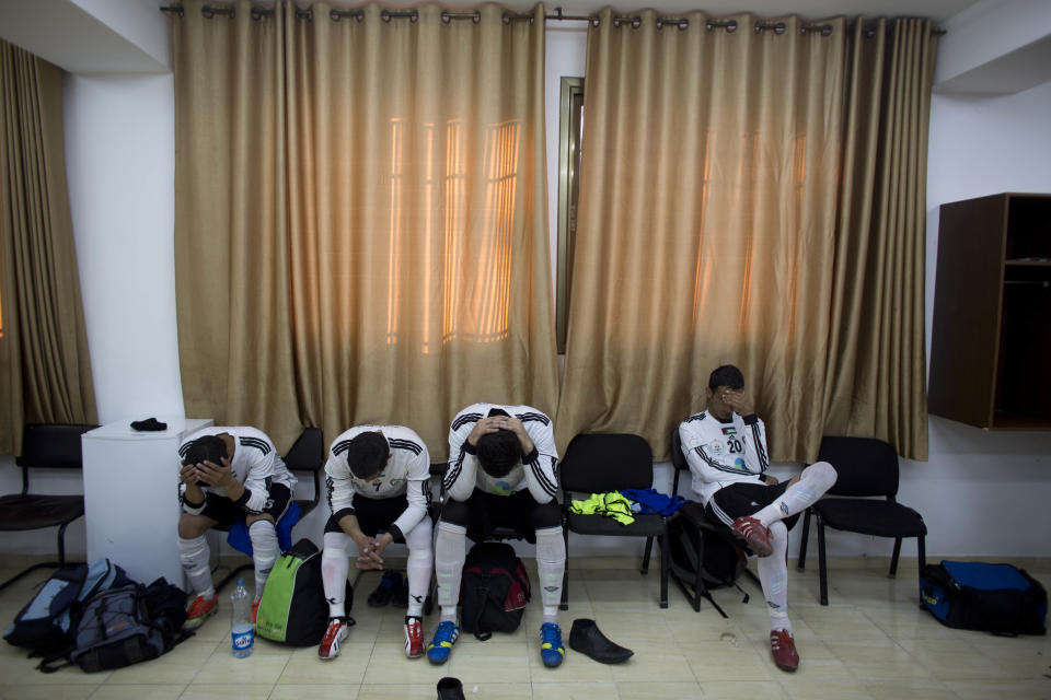 In this Friday Feb. 7, 2014 photo, Wadi al-Nees players sit dejected after losing first of a league game at a stadium in Hebron, West Bank. Palestinian farmer Yousef Abu Hammad sired enough boys for a soccer team and the current roster of the Wadi al-Nees team includes six of Abu Hammad's sons, three grandsons and five other close relatives. Wadi al-Nees heads the West Bank's 12-team “premier league,'' consistently defeating richer clubs and believe their strong family bonds are a secret to their success. (AP Photo/Dusan Vranic)