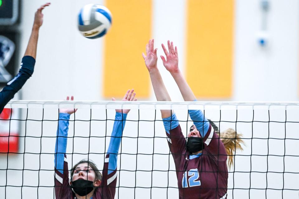 Okemos' Ali Pignataro, left, and Kennedi North go to block a Skyline hit during the third set on Tuesday, Nov. 9, 2021, at DeWitt High School.