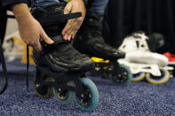 FILE - Mohamed Soliman of Atmos Gear dons Atmos Gear inline electric skates during CES Unveiled before the start of the CES tech show, Tuesday, Jan. 3, 2023, in Las Vegas. More than a thousand startups are showcasing their products at the annual CES tech show in Las Vegas, hoping to create some buzz around their gadgets and capture the eyes of investors who can help their businesses grow.(AP Photo/John Locher, File)
