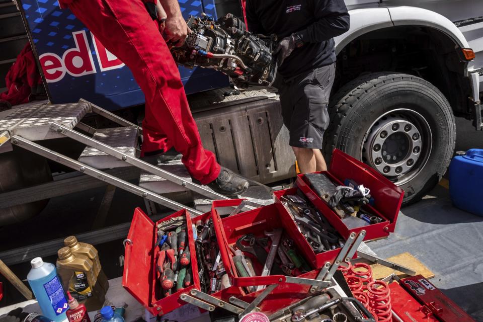 In this Saturday, Jan. 11, 2020 photo, Red Bull mechanics work at the Dakar Rally bivouac in Riyadh, Saudi Arabia. Formerly known as the Paris-Dakar Rally, the race was created by Thierry Sabine after he got lost in the Libyan desert in 1977. Until 2008, the rallies raced across Africa, but threats in Mauritania led organizers to cancel that year's event and move it to South America. It has now shifted to Saudi Arabia. The race started on Jan. 5 with 560 drivers and co-drivers, some on motorbikes, others in cars or in trucks. Only 41 are taking part in the Original category. (AP Photo/Bernat Armangue)
