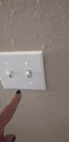 Hand flipping a light switch on and off in a repeated motion on a wall plate