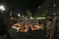 FILE - Flowers and tribute candles are laid out near the site of the truck attack in the French resort city of Nice, early Sunday, July 17, 2016. Eight people go on trial Monday Sept.5, 2022 in a special French terrorism court for alleged roles in helping the attacker who drove a truck into the Nice beachfront on Bastille Day 2016, killing 86 people. (AP Photo/Luca Bruno, File)