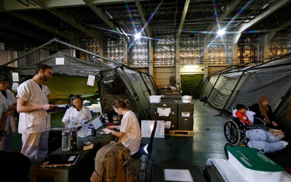 Military medical personnel work onboard the French LHD Dixmude military ship, which serves as a hospital to treat wounded Palestinians, as it docks at the Egyptian port of Al-Arish