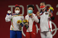 Gold medalist, Hou Zhihui of China, center, stands with silver medalist Mirabai Chanu Saikhom of India, left, and bronze medalist Windy Cantica Aisah of Indonesia, right, after the women's 49kg weightlifting event, at the 2020 Summer Olympics, Saturday, July 24, 2021, in Tokyo, Japan. (AP Photo/Luca Bruno)