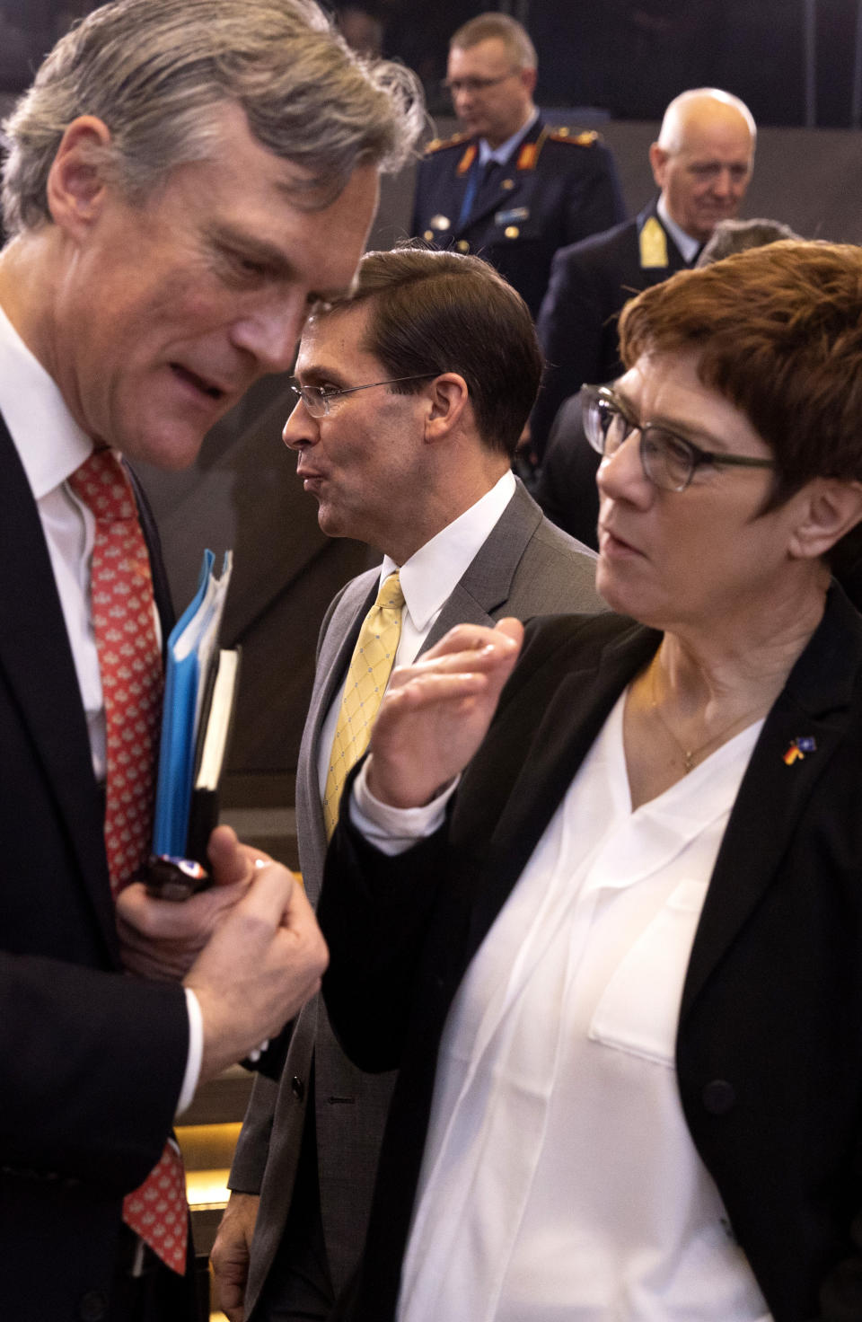 U.S. Secretary for Defense Mark Esper, center, passes behind German Defense Minister Annegret Kramp Karrenbauer, right, during a meeting of the North Atlantic Council at NATO headquarters in Brussels, Thursday, Feb. 13, 2020. NATO ministers, in a second day of meetings, will discuss building stability in the Middle East, the Alliance's support for Afghanistan and challenges posed by Russia's missile systems. (AP Photo/Virginia Mayo)