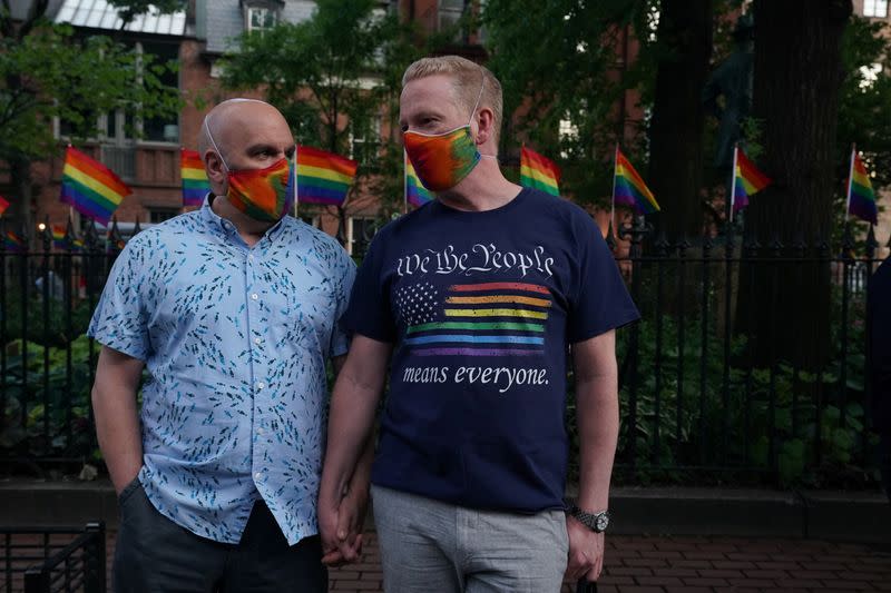 Stephen Cabral (L) and Brendan Byrnes (R) of the West Village attend a rally at the Stonewall Inn to support the Supreme Court decision to uphold LBGTQ+ workplace rights in New York