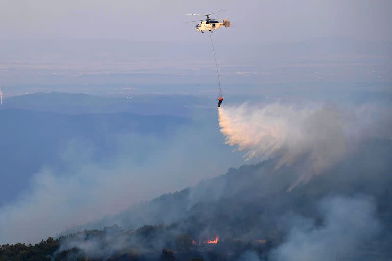 Un helicóptero de extinción de incendios arroja agua en medio de los esfuerzos por apagar un incendio forestal en la zona de Leptokarya, Evros, norte de Grecia. Según los bomberos, el principal foco del incendio de Evros se sitúa en la zona de Leptokarya, mientras que durante la noche se produjeron brotes en Dadia. En la operación en Evros participan potentes fuerzas de extinción de incendios terrestres, junto con bomberos voluntarios y fuerzas de las Fuerzas Armadas, asistidos por cuatro aviones y tres helicópteros. (incendio forestal, Grecia)EFE/EPA/DIMITRIS ALEXOUDIS
