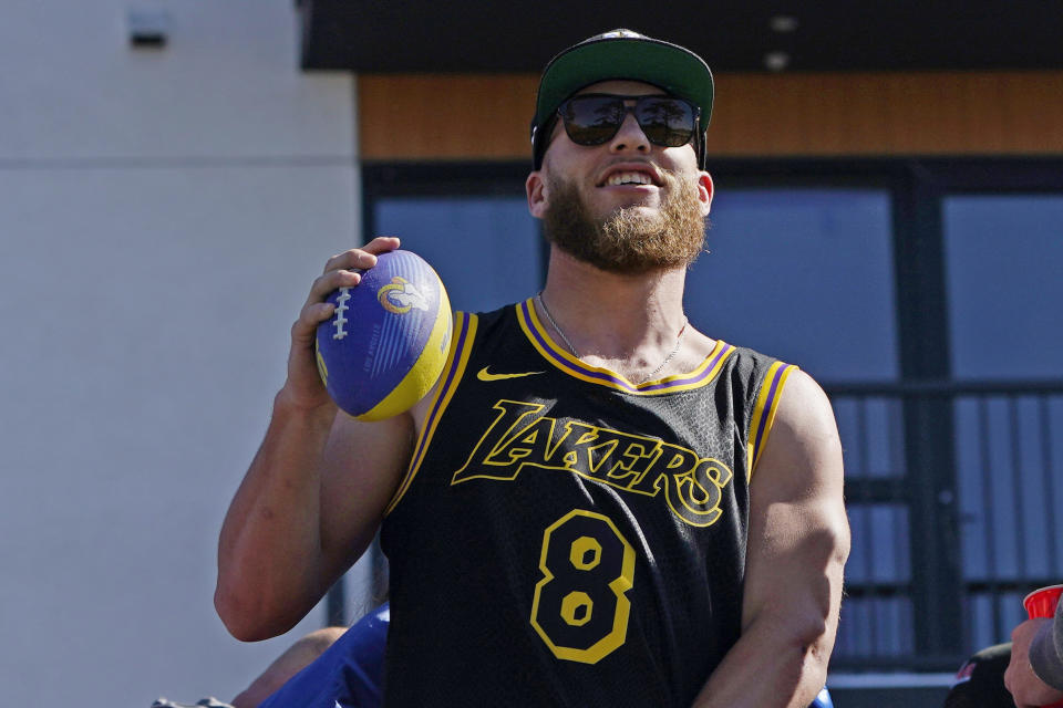 Los Angeles Rams wide receiver Cooper Kupp holds a football as he rides on a bus during the team's victory parade in Los Angeles, Wednesday, Feb. 16, 2022, following their win Sunday over the Cincinnati Bengals in the NFL Super Bowl 56 football game. (AP Photo/Marcio Jose Sanchez)