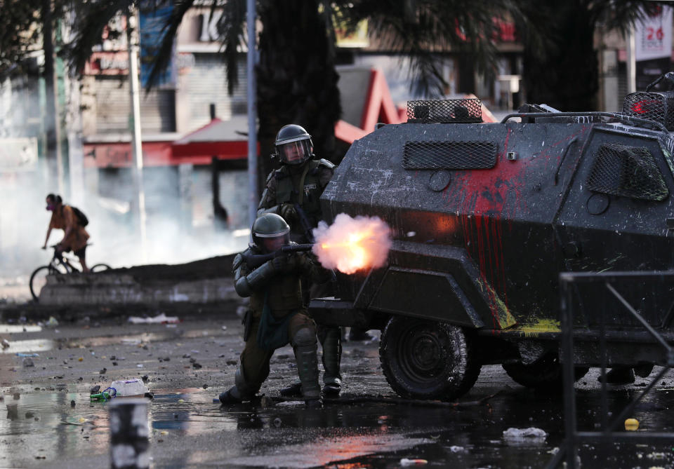 A police officer fires tear gas as demonstrators protest against Chile's state economic model in Santiago, Chile on Oct. 23, 2019. (Photo: Ivan Alvarado/Reuters)