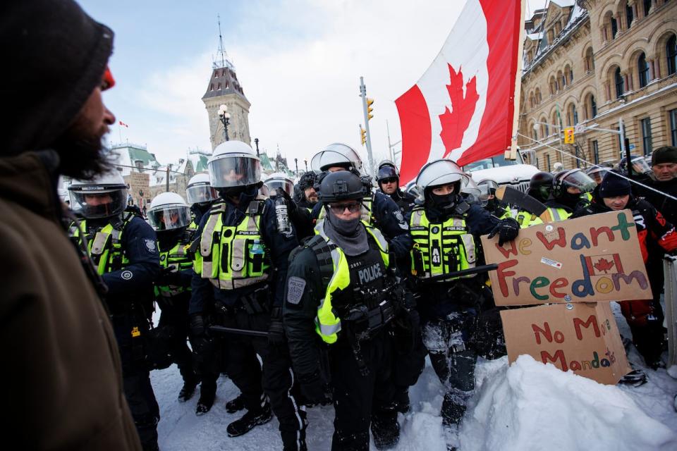 Protesters and police square off in front of Parliament Hill in Ottawa on Feb. 19, 2022. Some of those involved in the 'Freedom Convoy' two years ago say they plan to return this weekend to mark the anniversary. (Evan Mitsui/CBC - image credit)
