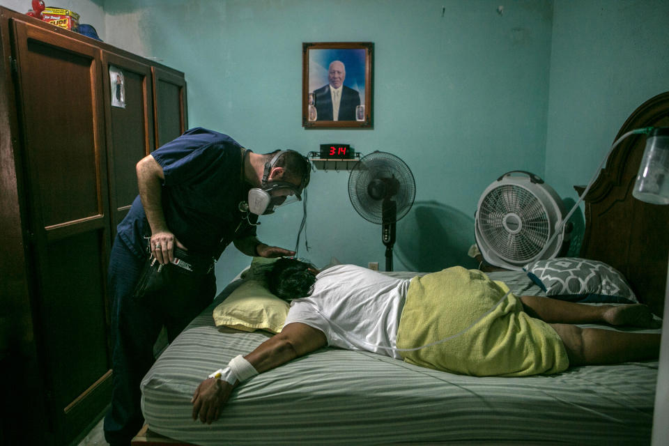 El doctor Gustavo Gutiérrez revisa a una paciente de covid. Calcula que desde junio ha visitado a unos 200  pacientes. (Meghan Dhaliwal/The New York Times)