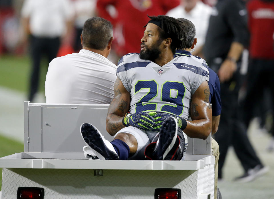 File - In this Sept. 30, 2018, file photo, Seattle Seahawks defensive back Earl Thomas (29) leaves the field after breaking his leg against the Arizona Cardinals during the second half of an NFL football game in Glendale, Ariz. Though the league's biggest stars receive hefty signing bonuses, the push for more guaranteed money across the life of contracts has slowly picked up steam over the past few seasons. The contract holdouts by Le'Veon Bell and Thomas during this season put the issue into vivid focus. (AP Photo/Ross D. Franklin, File)