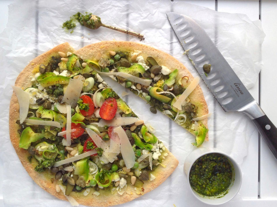 Green pizzaCelebrate Spring with a healthy green pizza. The choice of toppings is up to you – the greener the better!Ingredients (makes enough for 1 large pizza)For the pesto1 garlic clove, roughly chopped 60g basil leaves 125-250ml extra virgin olive oil 30g almonds 30g pine nuts 50g parmesan ½ tsp salt ¼ tsp freshly ground black pepperFor the quinoa pizza crust1 cup white quinoa (soaked overnight in water) 1 tbsp nutritional yeast flakes 1 tsp unfiltered apple cider vinegar Salt and freshly ground white pepperFor the toppings1 small courgette, finely sliced 2-3 spring onions, finely sliced Feta cheese, crumbled A handful of gherkins, chopped A handful of fresh peas 1 tbsp capers 5 cherry tomatoes, halved A handful of pine nuts A handful of pumpkin seeds Half an avocado, peeled and shaved with a speed peeler 1 sprig lemon thyme, leaves picked Zest of half a lemon Parmesan shavingsTo make the pestoPut the garlic, basil and 125ml of olive oil into a food processor and blend until smooth. Add the almonds, pine nuts, parmesan, salt and pepper and pulse until the mixture is chunky, adding more olive oil if you like a runnier texture. Taste and adjust the seasoning if necessary.To make the pizza crustSoak the quinoa overnight in a large bowl, make sure it is completely covered by water, if you’re uncertain just add a bit more, any excess will be drained off before making the pizza crust.Preheat your oven to 190C/375F/Gas 5.Drain and rinse the quinoa then put into a food processor with the nutritional yeast, vinegar, salt and pepper. Blitz until smooth, it won’t form a dough it will be quite runny, this is the way it should be so don’t worry.Pour the mixture onto a lipped baking tray lined with a silicone baking mat and cook for 15-20 minutes until firm. Remove from the oven and carefully peel off the baking mat. Flip the crust over and return to the oven for a further 5-10 minutes. If you want a warm pizza don’t let your crust colour too much around the edges at this stage as it will going back in the oven, if you are going to have a raw pizza then let it bake until golden.To assemble the pizzaRemove the pizza base from the oven and spread a couple of tablespoons of pesto all over, cover with some courgettes, spring onions and feta cheese. Now, simply add the rest of your toppings and enjoy hot or cold.Follow Beverley Hicks @littlechelseakitchen