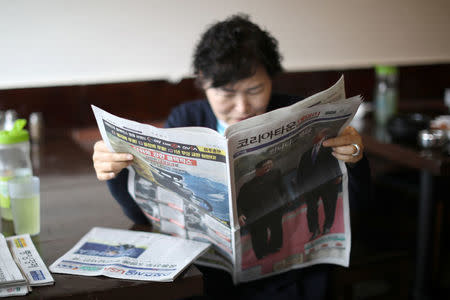 A woman reads a newspaper with a front page story about the inter-Korean summit between North Korea’s Kim Jong Un and South Korean President Moon Jae-in, in Koreatown, Los Angeles, California, April 27, 2018. REUTERS/Lucy Nicholson