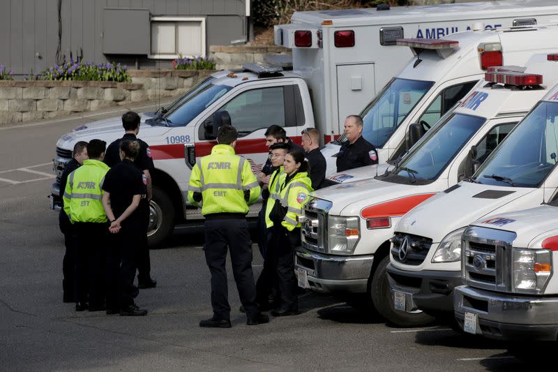 Medics wait near ambulances in a staging area at the North Kirkland Community Center, which is a short drive from the Life Care Center of Kirkland, the long-term care facility linked to several confirmed coronavirus cases in the state, in Kirkland