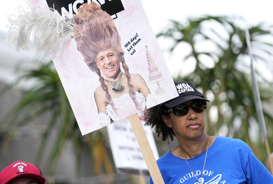 Shelley Meals, miembro de Sindicato de Guionistas de Estados Unidos, lleva un cartel que muestra al director general de Disney, Bob Iger, como María Antonieta en una protesta frente a los estudios de Netflix el miércoles, 9 de agosto de 2023, en Los Ángeles. La huelga de guionistas de Hollywood alcanzó hoy la marca de los 100 días, las industrias del cine y la televisión de Estados Unidos siguen paralizadas por huelgas de guionistas y actores. (Foto AP/Chris Pizzello)