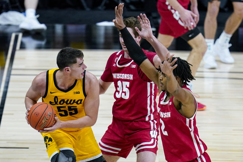 Iowa center Luka Garza (55) gets trapped on the baseline by Wisconsin forwards Nate Reuvers (35) and Aleem Ford (2) during the second half of an NCAA college basketball game at the Big Ten Conference men's tournament in Indianapolis, Friday, March 12, 2021. (AP Photo/Michael Conroy)