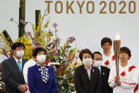 FILE - In this March 25, 2021, file photo, Tokyo Gov. Yuriko Koike, third from left, and Tokyo 2020 Organizing Committee President Seiko Hashimoto, fourth from left, wearing face masks, attend the Tokyo 2020 Olympic Torch Relay Grand Startin Naraha, Fukushima prefecture, northeastern Japan. The torch relay for the postponed Tokyo Olympics began its 121-day journey across Japan on March 25 and is headed toward the opening ceremony in Tokyo on July 23. (Kim Kyung-Hoon/Pool Photo via AP, File)